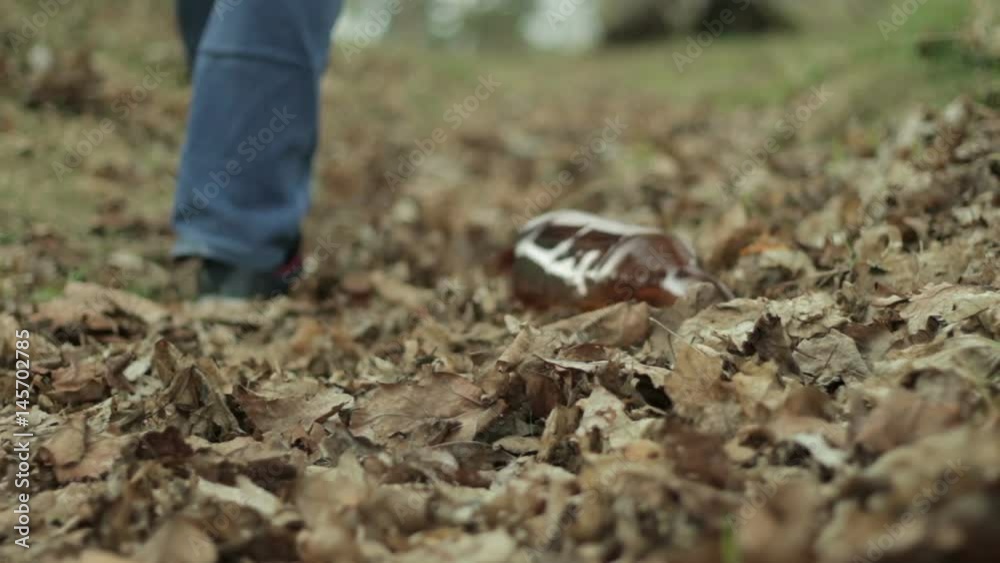 Man throws garbage into dry foliage Man throws garbage into dry foliage