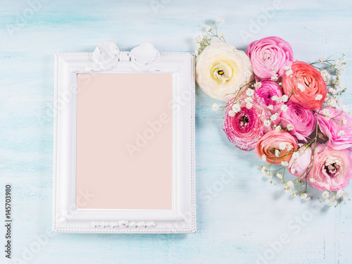 Beautiful buttercup frame on turquoise wooden background. Woman mother's day wedding. Holiday elegant bunch of flowers. Pink card to fill with text
