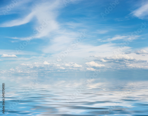Blue sky with white clouds and water surface