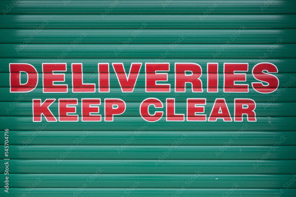 Deliveries keep clear sign on shuttered door Deliveries keep clear sign on shuttered door