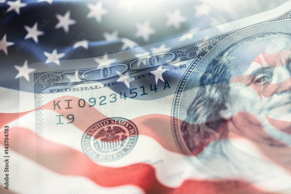 USA flag and American dollars. American flag blowing in the  wind and 100 dollars banknotes in the background. - obrazy, fototapety, plakaty 