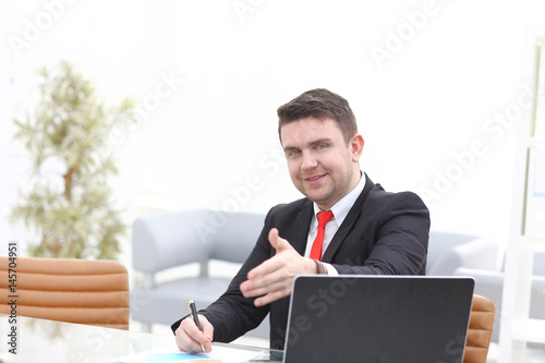 business and office concept - handsome businessman with hand ready for handshake