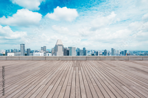 empty wooden floor with cityscape of modern city