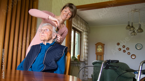 Betreuerin kämmt Seniorin