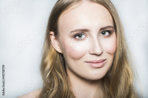 Face of young blonde beautiful girl with makeup and long hair
