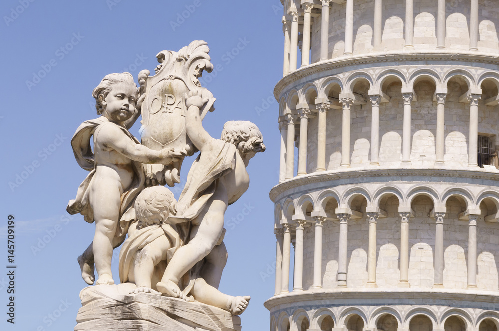 estatua niños junto a torre de Pisa