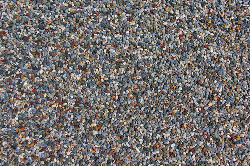 Texture of lots of small colorful pebbles on the ground. 