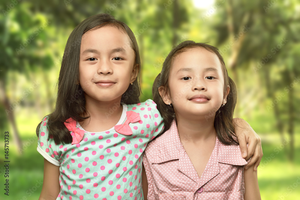 Funny two little sisters standing and hugging Funny two little sisters standing and hugging