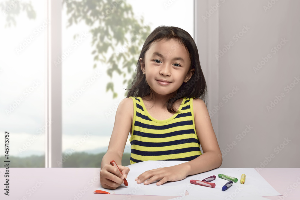 Happy asian child drawing with crayon on white paper Happy asian child drawing with crayon on white paper