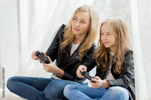 Family games. Mother and daughter play on conlsole together photo