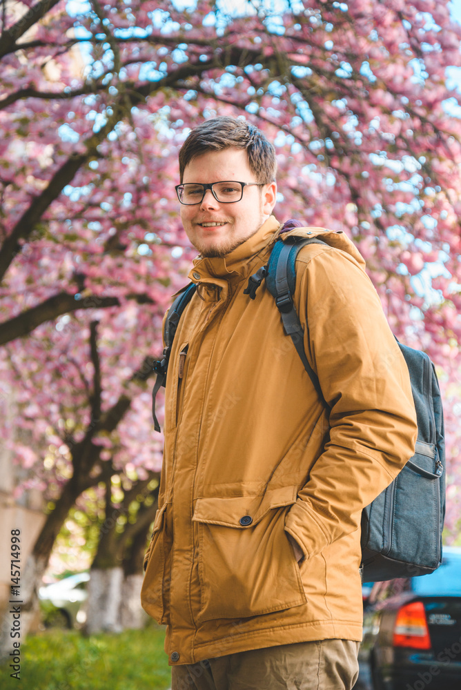 portrait of the yang man in glasses with blooming sakura portrait of the yang man in glasses with blooming sakura