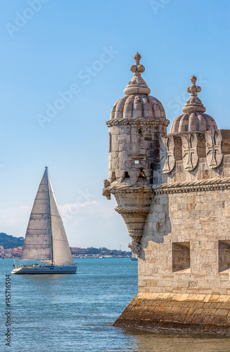 Protective corner turret on the Tower of Belem (Torre de Belem), the river Tejo (Tagus) with whitw sial in the background - Lisbon, Portugal photo