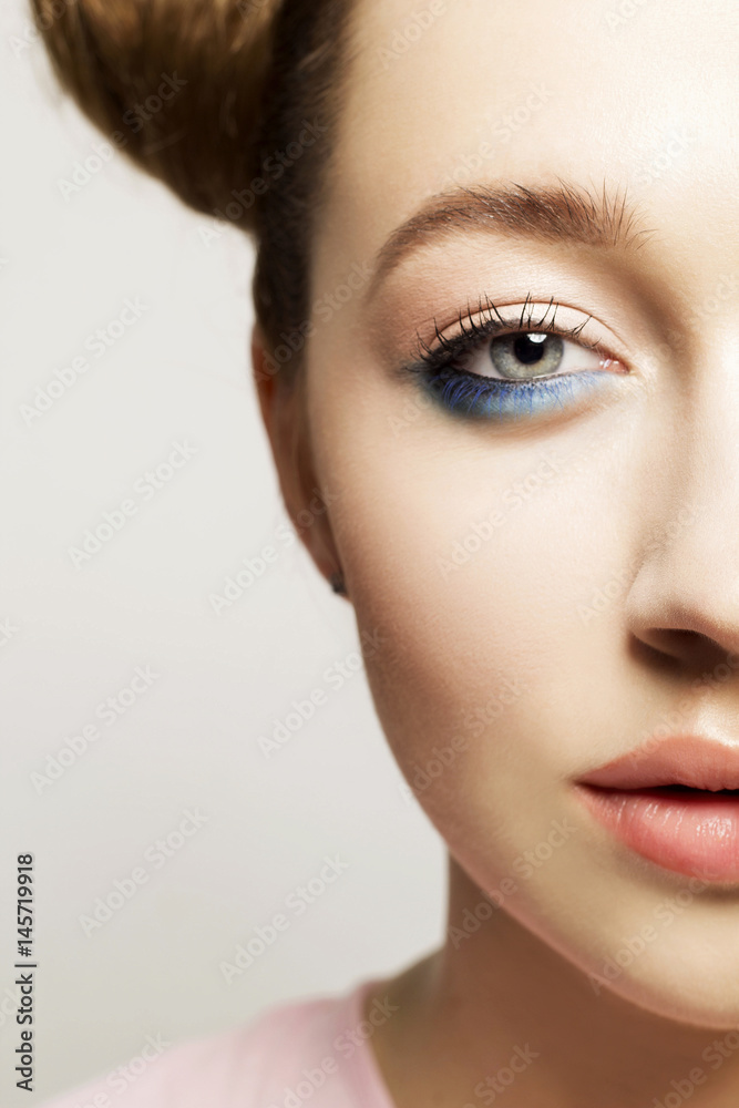 Portrait of beautiful woman with blue make up on eyes and blue glitter in hair. Beauty concept. Portrait of beautiful woman with blue make up on eyes and blue glitter in hair. Beauty concept.