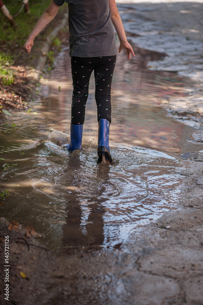 Kid jumping into a puddle