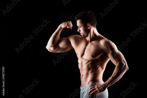 Fotografia Muscular and sexy torso of young man having perfect abs, bicep and chest
