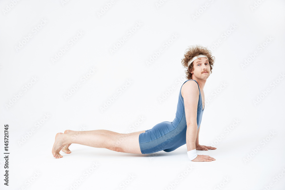 Bhujanqasana. Man in blue jumpsuit practising yoga for first time