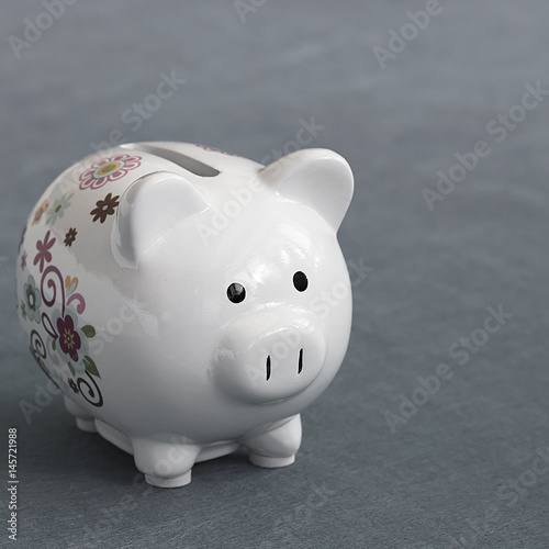 A white piggy bank on gray background.