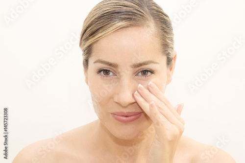 Woman applies moisturizing serum on her face