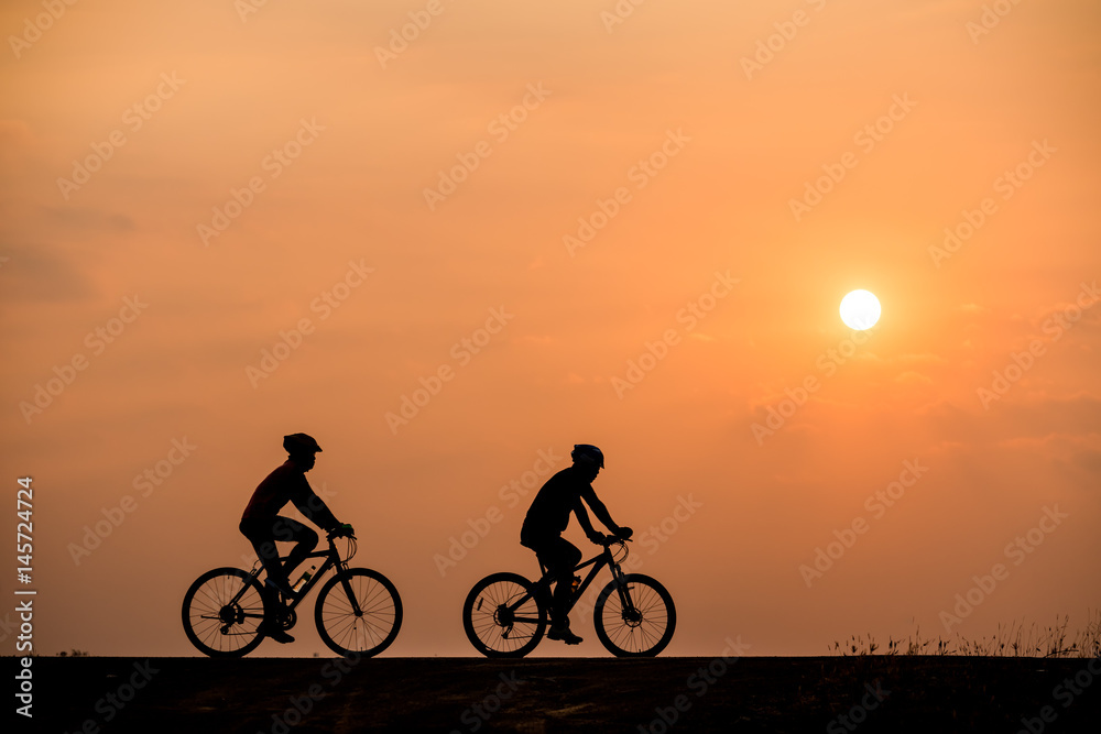 Obraz premium Silhouette of cyclist on sunset background