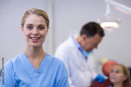 Smiling dental assistant standing in dental clinic photo