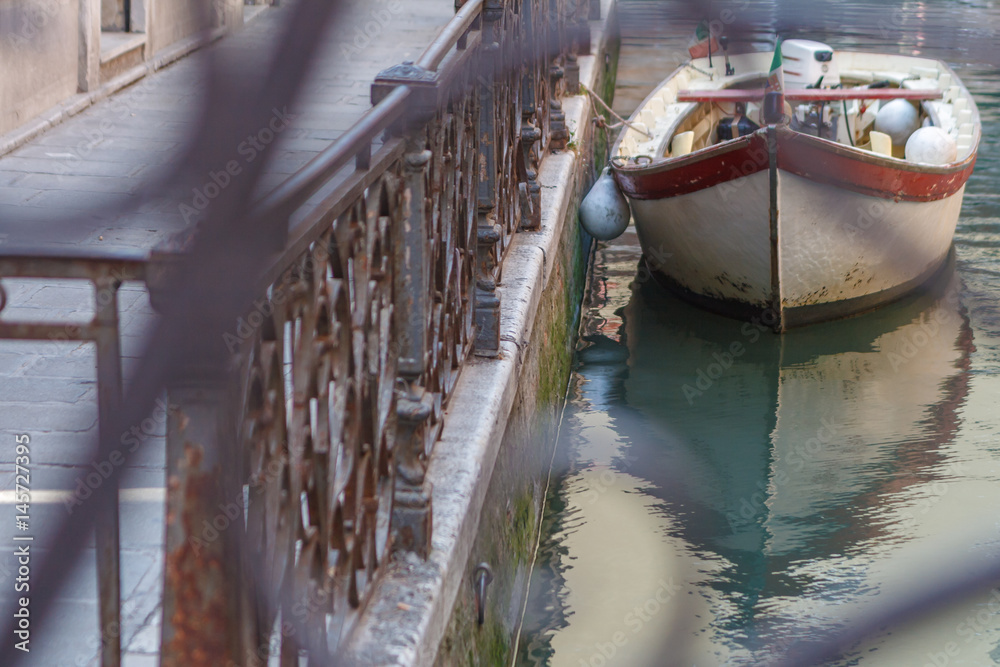 Simple Venice - Boat parked at the canal fence. Conceptual image from the brige. Italy