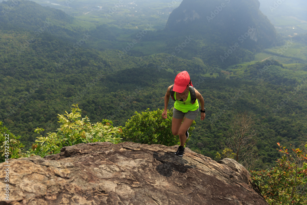 Obraz premium Young fitness woman trail runner running at mountain top