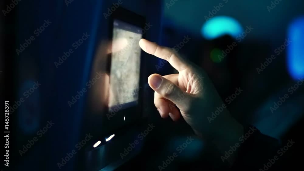 Passenger hand using airplane in flight entertainment touch screen to see flight detail map