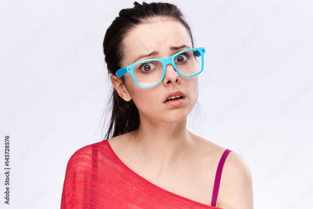 young woman in blue glasses, indignation