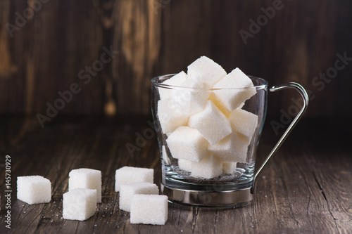 Fotografie Excessive portion of sugar in mug with tea