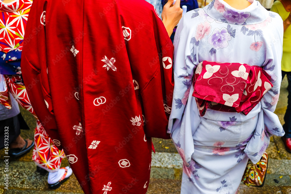 Naklejka premium Japanese Couple's wearing traditional Kimono dress at Fushimi Inari Temple