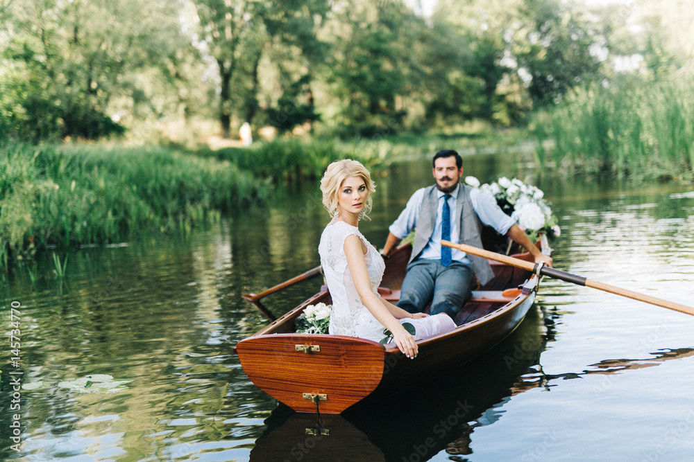 Young wedding couple posing on the boat