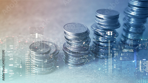 Double exposure of city and rows of coins for finance and banking concept
