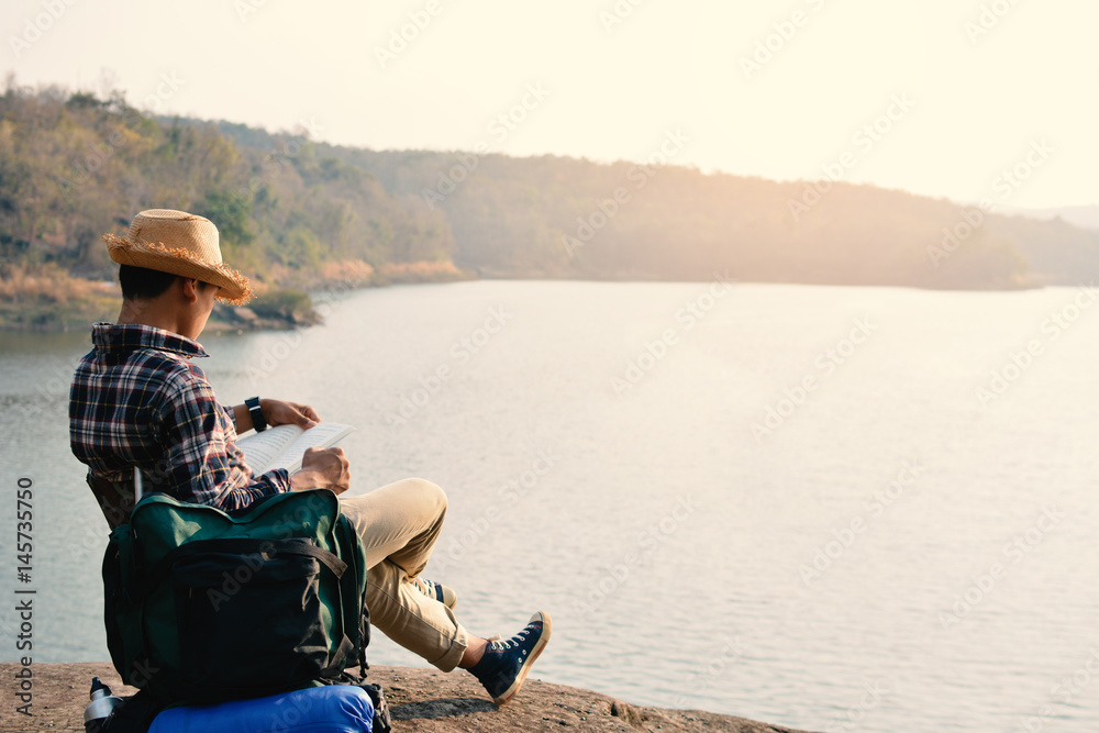 Fototapeta premium Happy Asian hipster man backpack in nature background, Relax time on holiday concept travel , color of vintage tone and soft focus