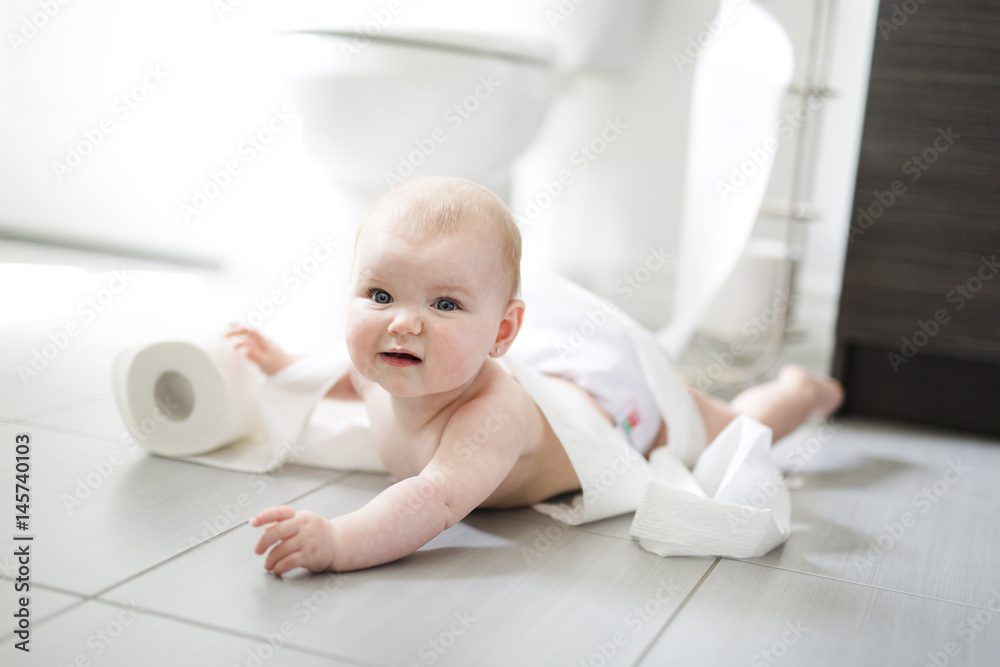 Toddler ripping up toilet paper in bathroom Toddler ripping up toilet paper in bathroom