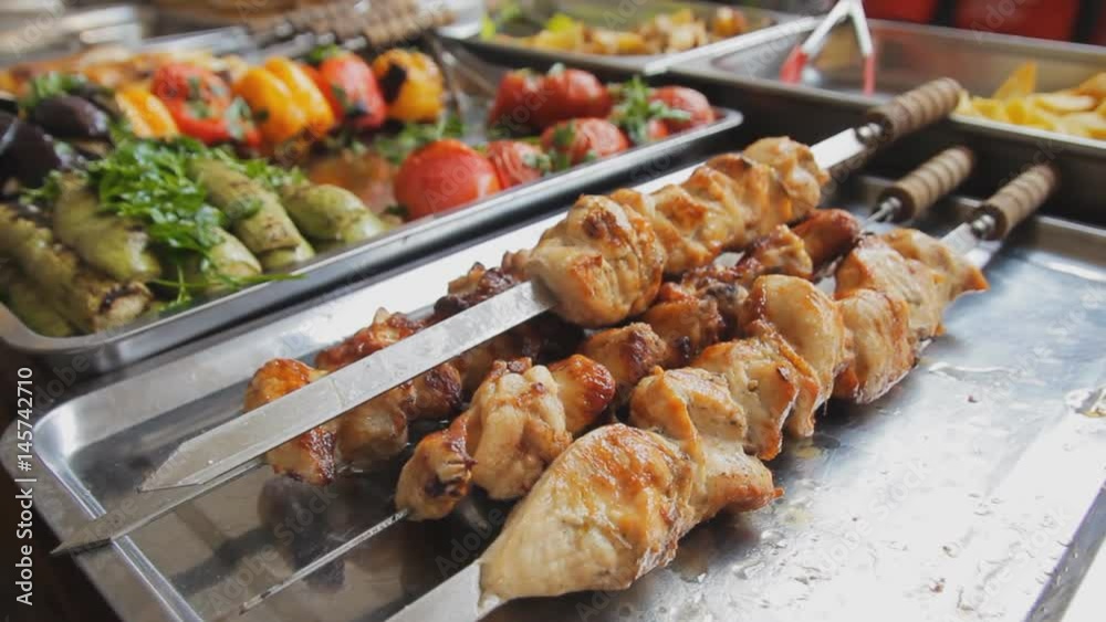 Barbecue meat on the pan. Grilled chicken and vegetables at the market. Barbecue chicken on skewers. A lot of grilled food. Shashlik. Zooming camera. Barbecue meat on the pan. Grilled chicken and vegetables at the market. Barbecue chicken on skewers. A lot of grilled food. Shashlik. Zooming camera.