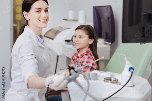 Attractive female otolaryngologist holding ent instrument