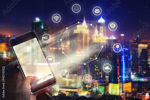 Mobile with wireless communication network and night city background. E-commerce business. internet of things.
