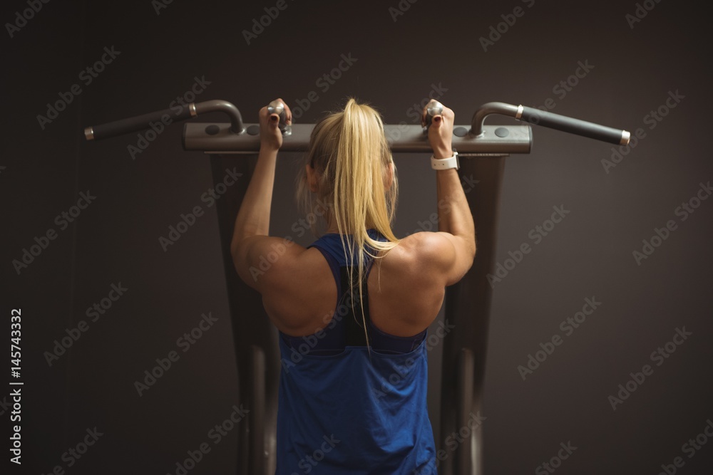 Rear view of fit woman exercising on a machine Rear view of fit woman exercising on a machine