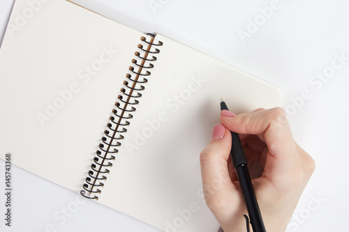 Notebook and pen in hand. Isolated on white background.