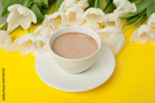 Coffee cup and white flower bouquet