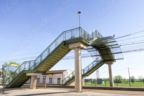Fototapet metal footbridge passes over the railway track train