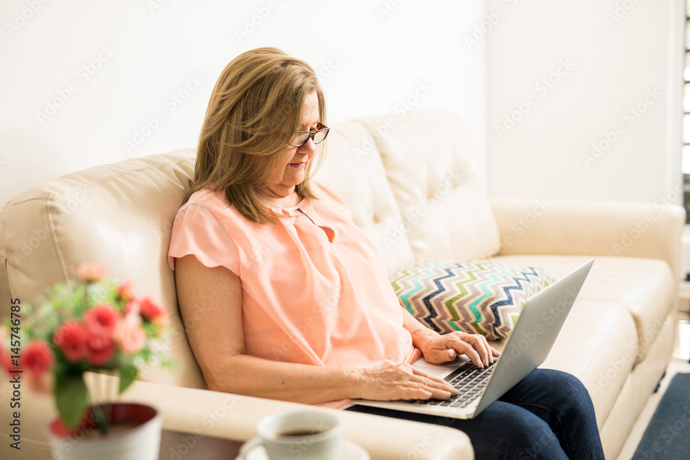Elder woman typing on her computer Elder woman typing on her computer