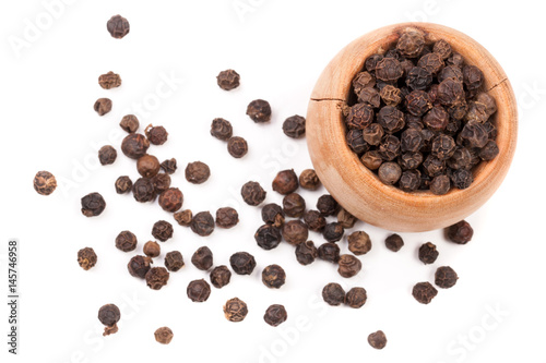 Black peppercorn in a wooden bowl isolated on white background. Top view