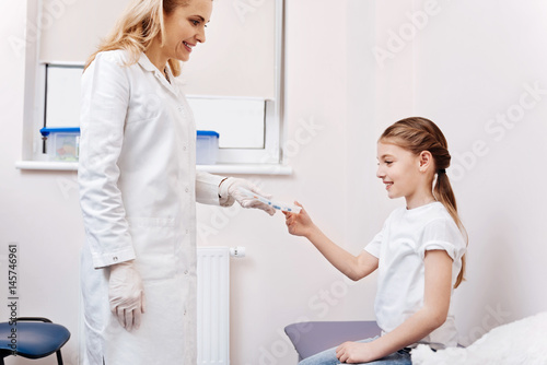 Smiling doctor standing opposite her patient