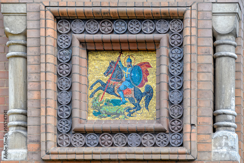 Mosaic coat of arms on brick wall
