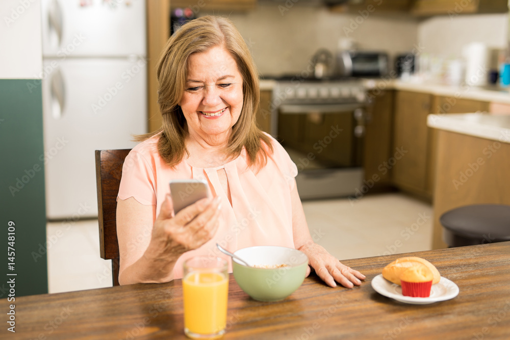 Happy senior woman looking at her smartphone