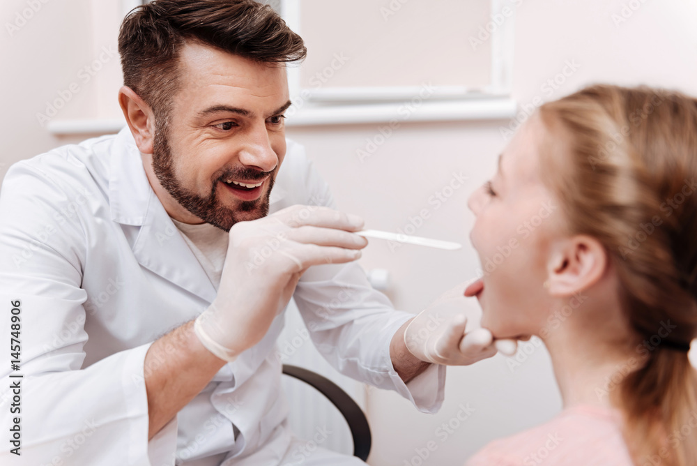Obraz premium Attentive pediatrician doing throat exam