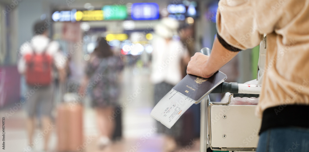 Closeup of girl holding passports and boarding pass at airport Closeup of girl holding passports and boarding pass at airport