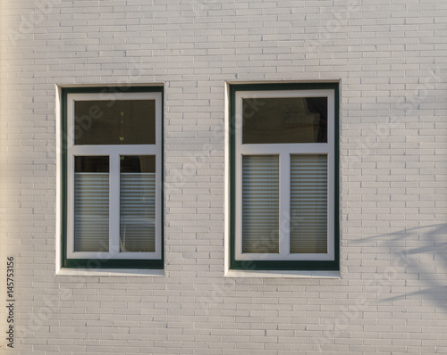Zwei Fenster in einer weißen Fassade