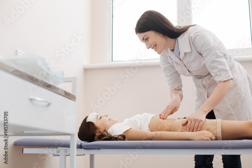 Nice pleasant girl lying on the medical bed photo
